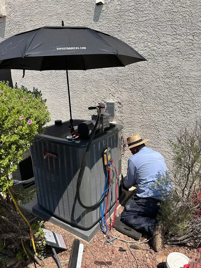 HVAC technician performing outdoor AC maintenance in Denham Springs