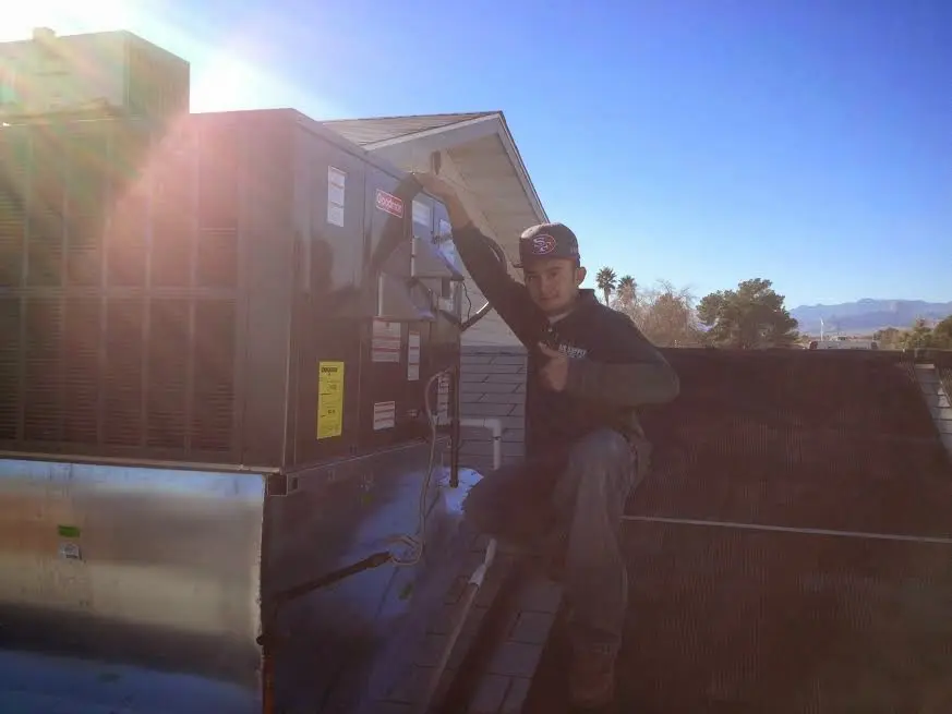 HVAC technician performing HVAC Inspection on a rooftop unit in Denham Springs
